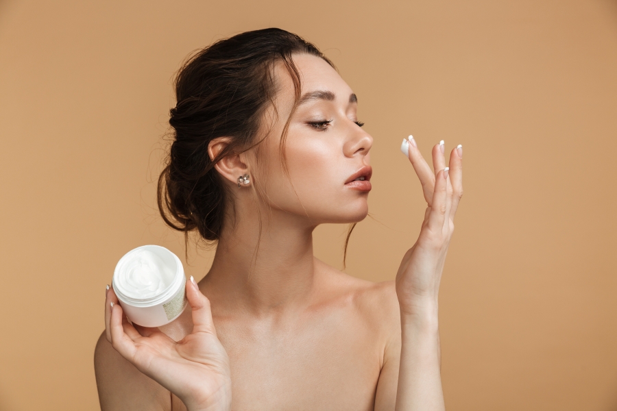 Lady applying face cream.